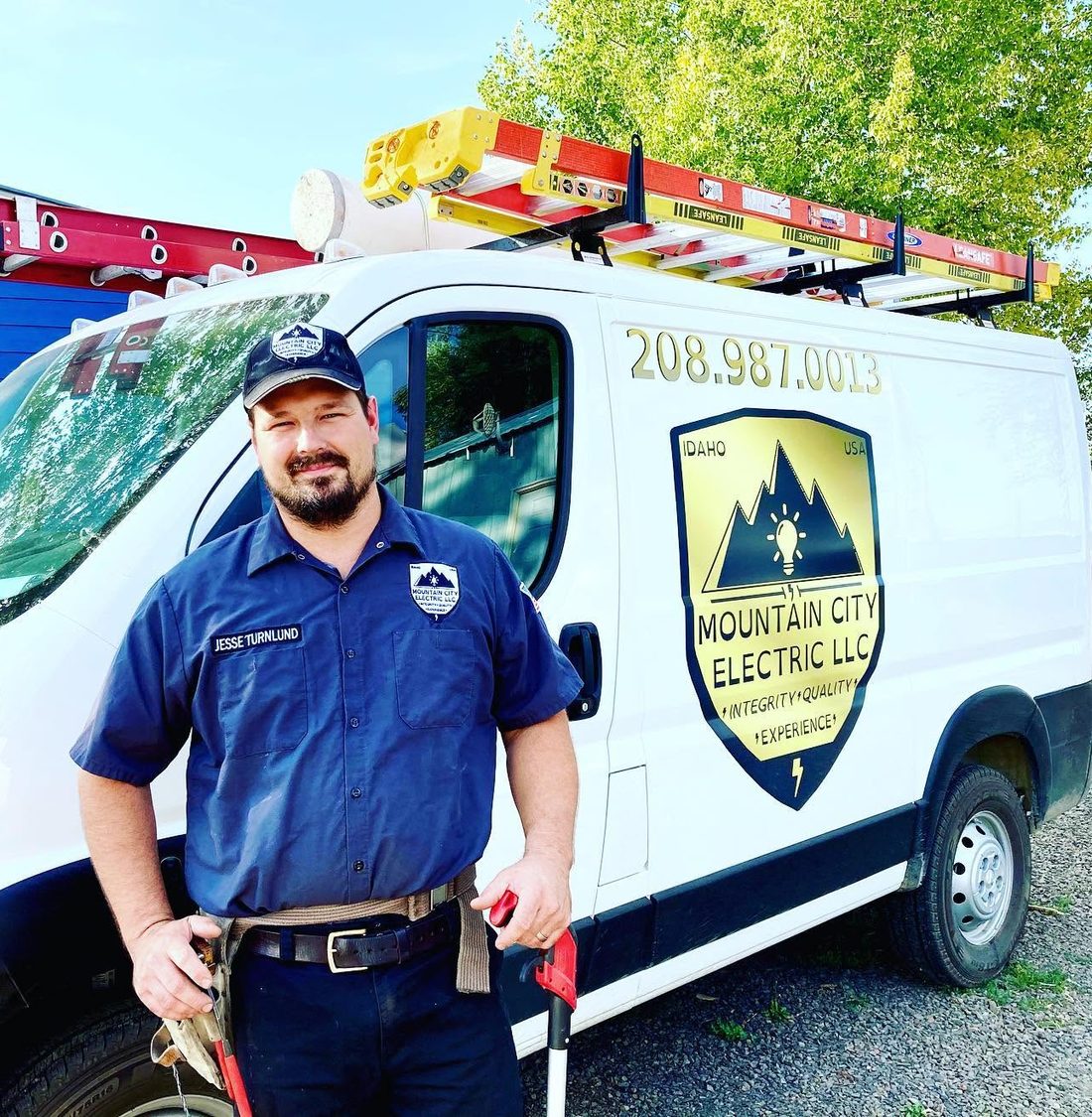 Jesse Turnlund of Mountain City Electric standing beside his service van in North Idaho